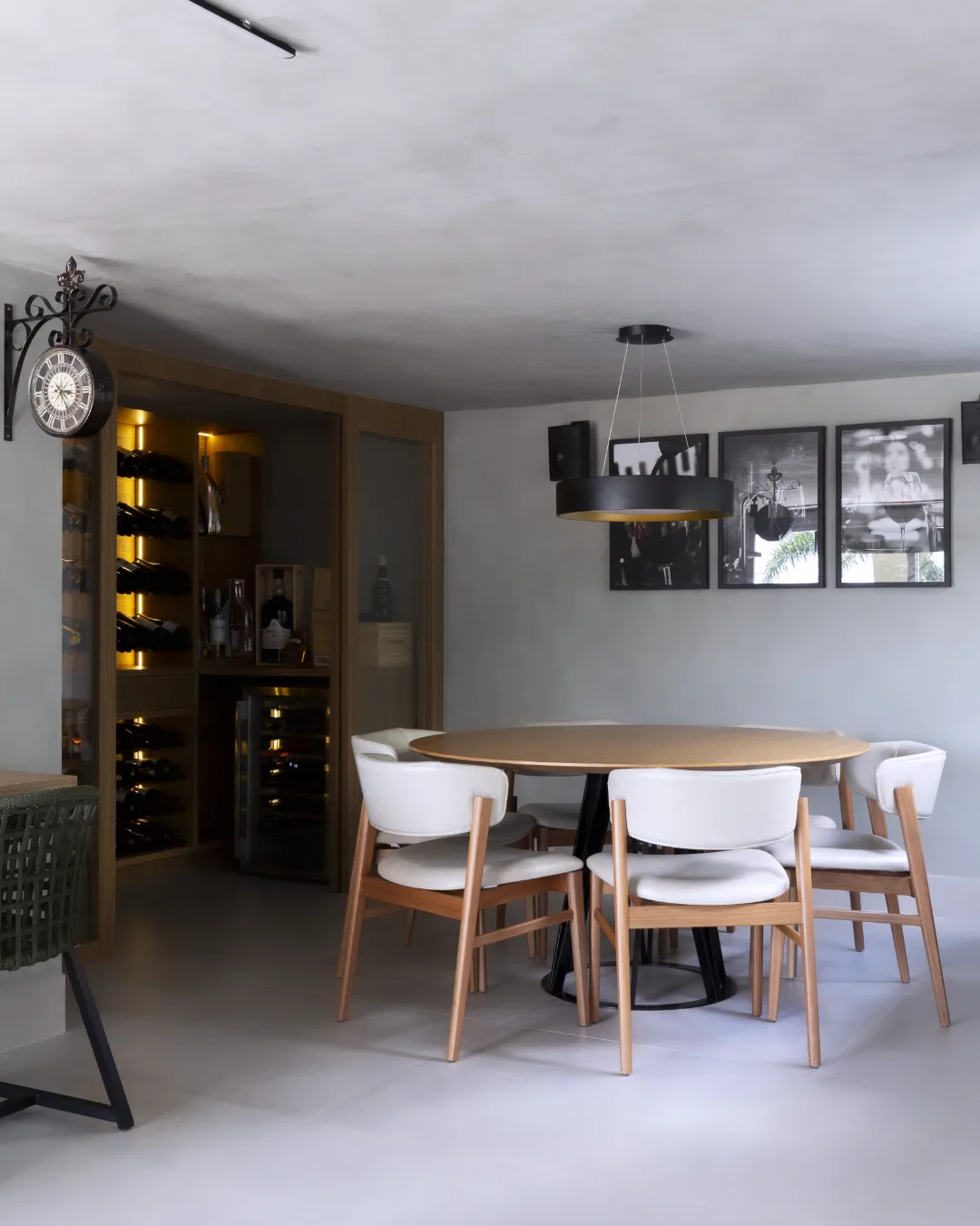 Sala de jantar com adega climatizada, mesa redonda e iluminação de destaque