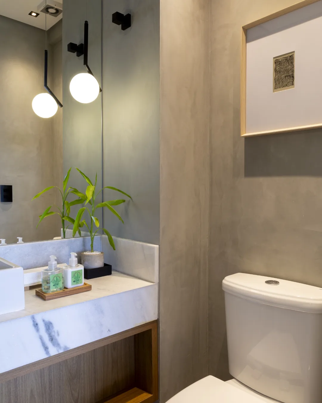 Lavabo com cimento queimado, bancada de mármore e pendente esférico