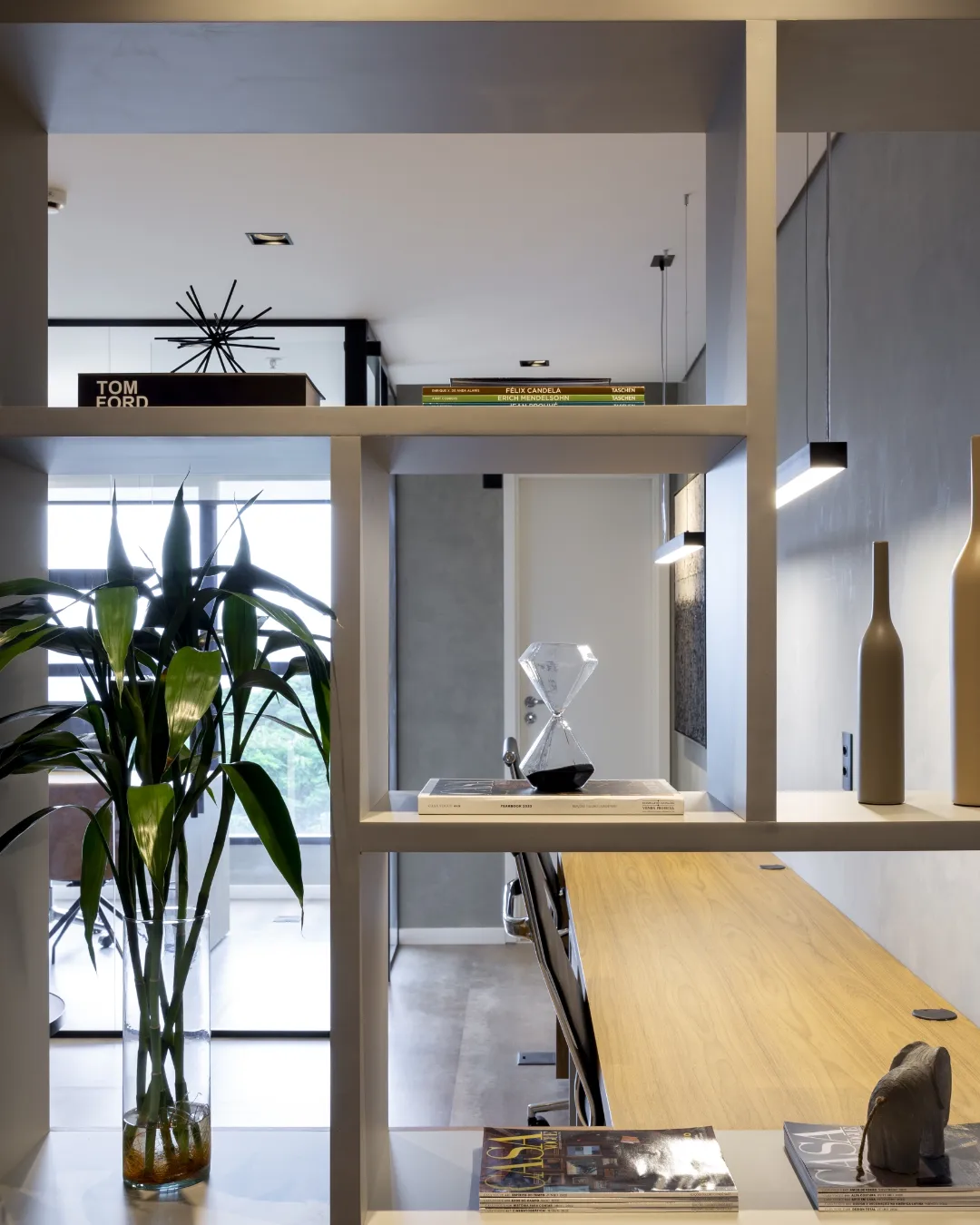 Estante de home office com livros de arquitetura e objetos de design